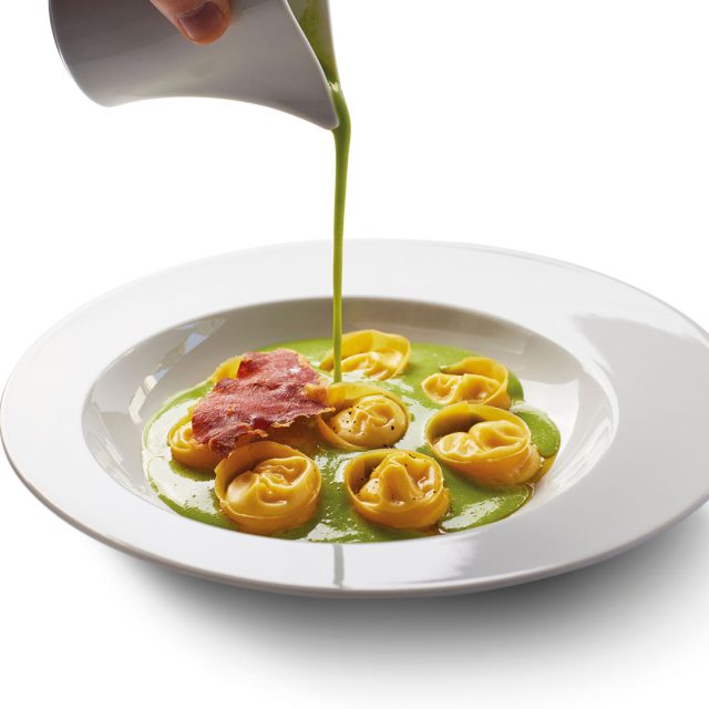 O cappelletti é uma de nossas massas artesanais mais versáteis, estrelando vários de nossos pratos. Um de nossos preparos mais pedidos é o cappeletti de parmesão recheado com parmesão líquido, creme de ervilha e presunto parma crocante. Presente em nosso menu a la carte durante todo o ano.