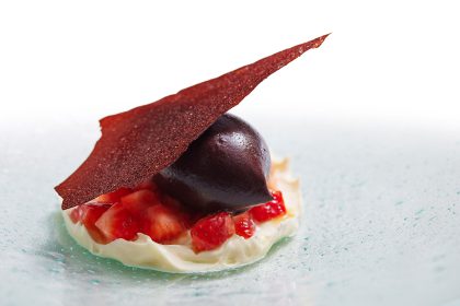 Creme de mascarpone, pedaços de morango marinados em redução de laranja-Bahia, sorbet de açaí e telha do próprio fruto, vindo diretamente de Belém.