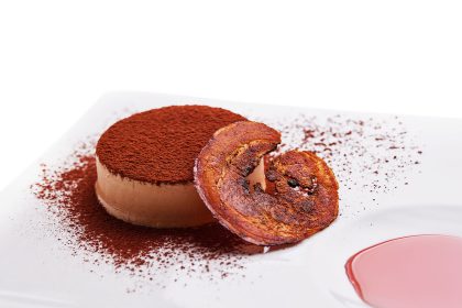 Nosso semifreddo de amendoim acompanhado por pancetta crocante, cacau em pó e calda de Campari.
