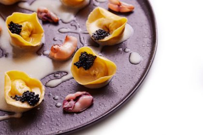 Prato tradicional de nosso cardápio a la carte, o tortelli de bacalhau é finalizado com ovas de caviar e molho de limão siciliano, com mini lulas grelhadas acompanhando.